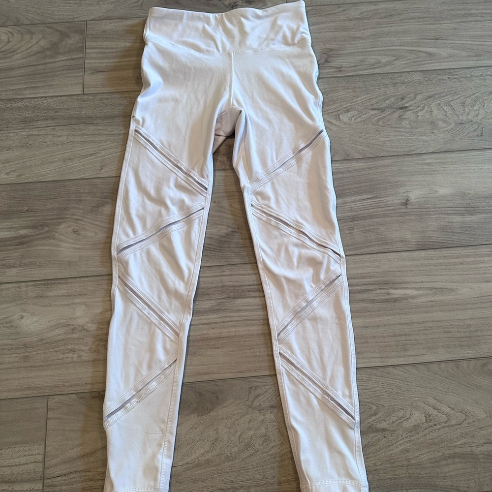 White fashion nova leggings with mesh lines across thigh